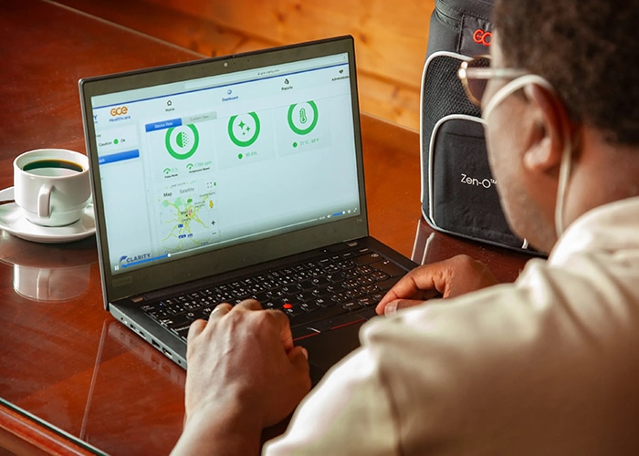 Mies istuu pöydän ääressä ja käyttää GCE Medical Clarity -verkkopalvelua tietokoneellaan.